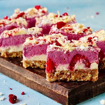 Kokos Himbeere Bites auf Holzbrett angerichtet und aufgeschnitten