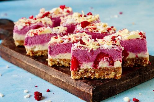 Kokos Himbeere Bites auf Holzbrett angerichtet und aufgeschnitten