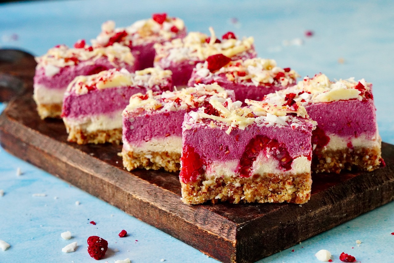 Kokos Himbeere Bites auf Holzbrett angerichtet und aufgeschnitten